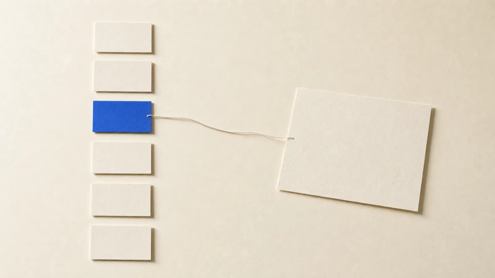 On a paper surface, a column of short word cards on the left and one larger card on the right; one of the cards is cobalt blue